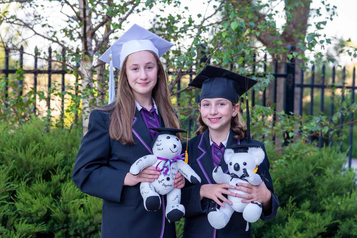 Two school students with a Graduation Signature Bear and Graduation Signature Koala
