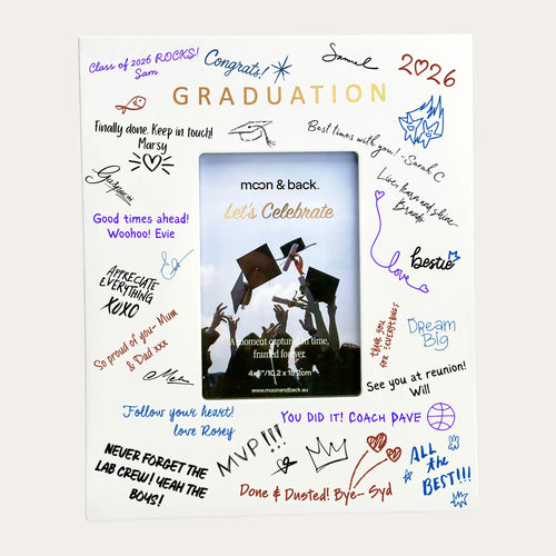 A matte white graduation photo frame with a central insert showing a graduation scene, surrounded by colorful handwritten-style text and doodles celebrating the milestone.